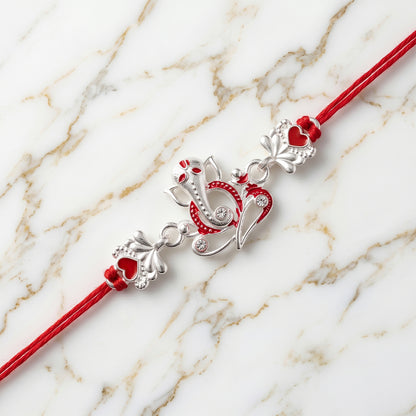 Silver Ganesha Rakhi with Red Stone Hearts and Deep Velvet Look