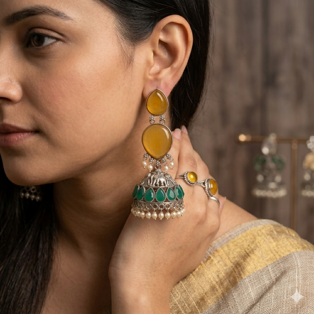 Detailed oxidized silver jhumka with mustard yellow and green stones