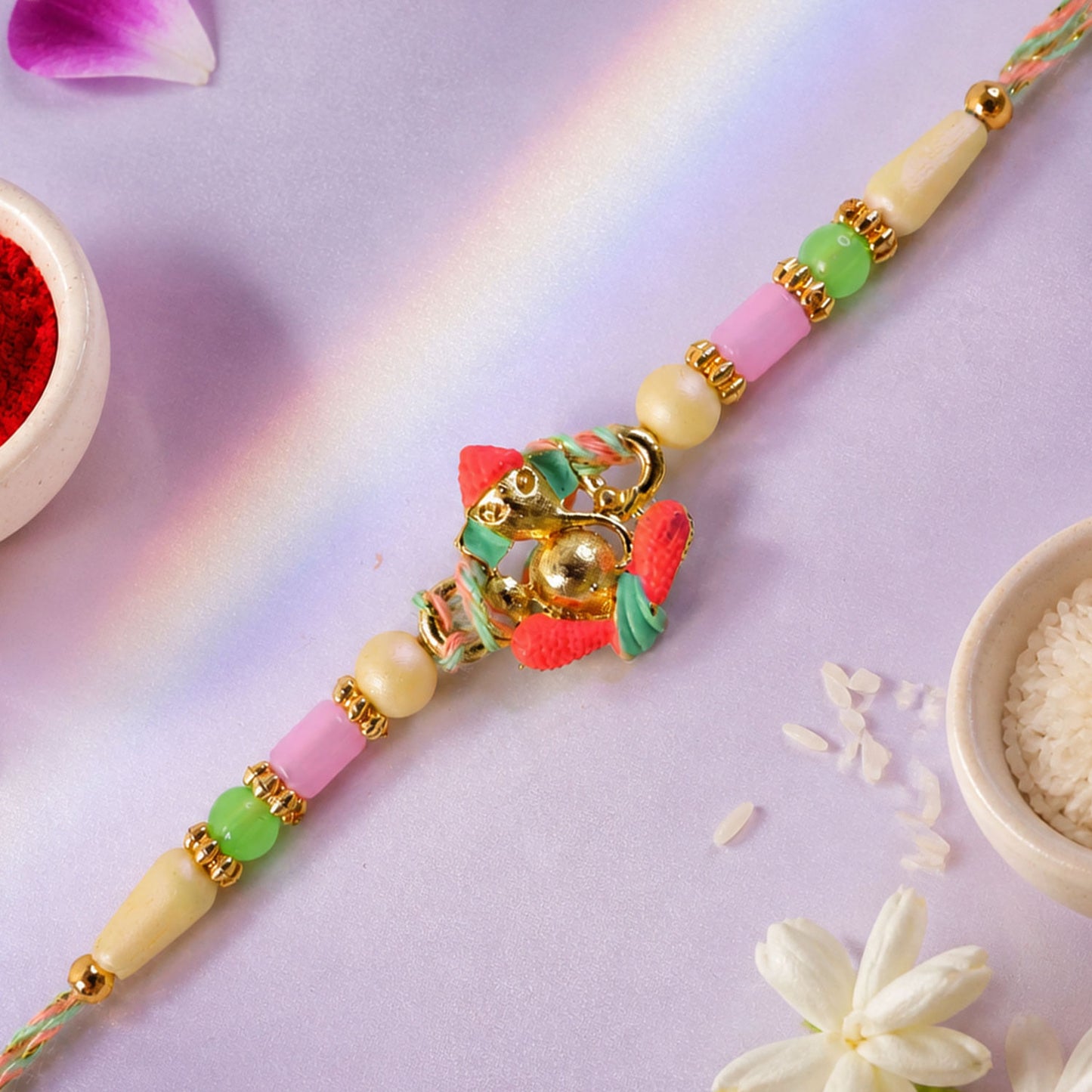 Gold Ganesha Charm Rakhi with Coral and Green Accents
