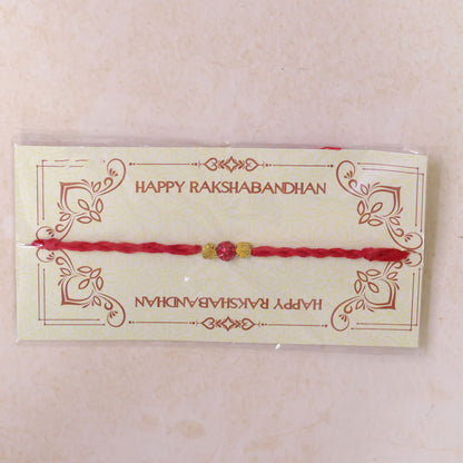 Red Thread Rakhi with Sparkling Red Ball Bead and Gold Flower Accents