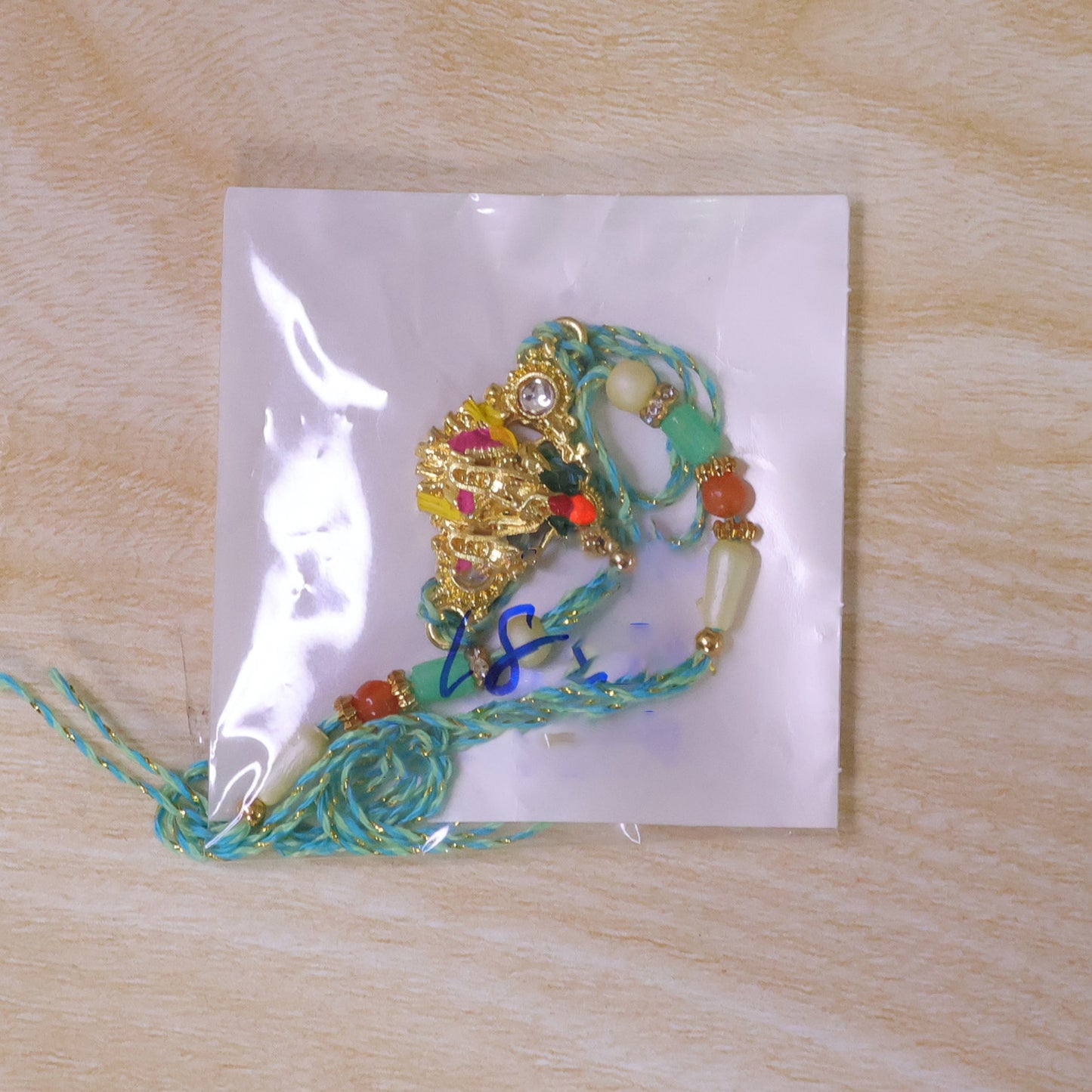Lord Krishna Flute Pendant Rakhi with Pink and Yellow Drapery