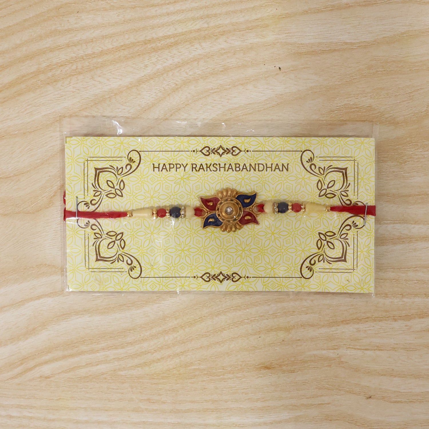 Gold Sunburst Rakhi with Blue Red Beads and Pearl Accents