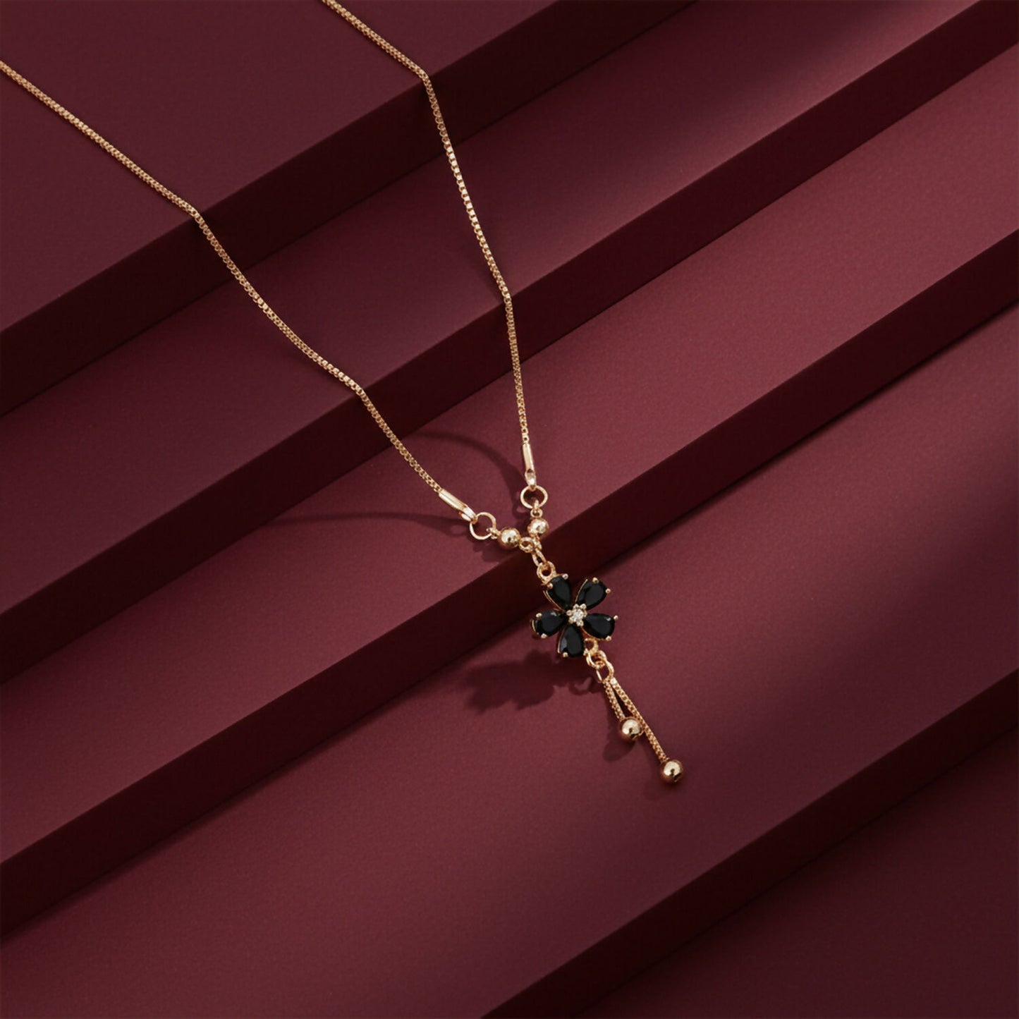 Close-up of black floral pendant with stones on gold finish necklace