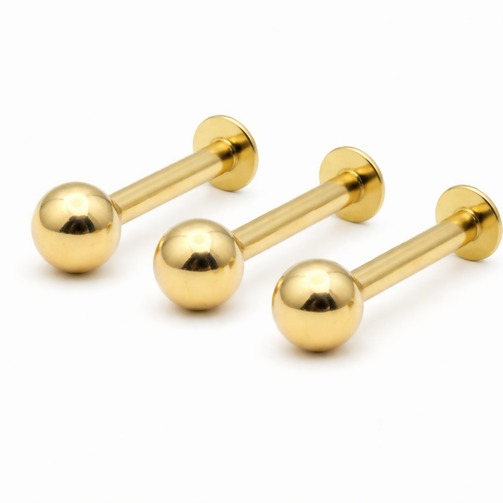 Pair of minimalist gold-plated flat back labret stud earrings showcasing polished finish