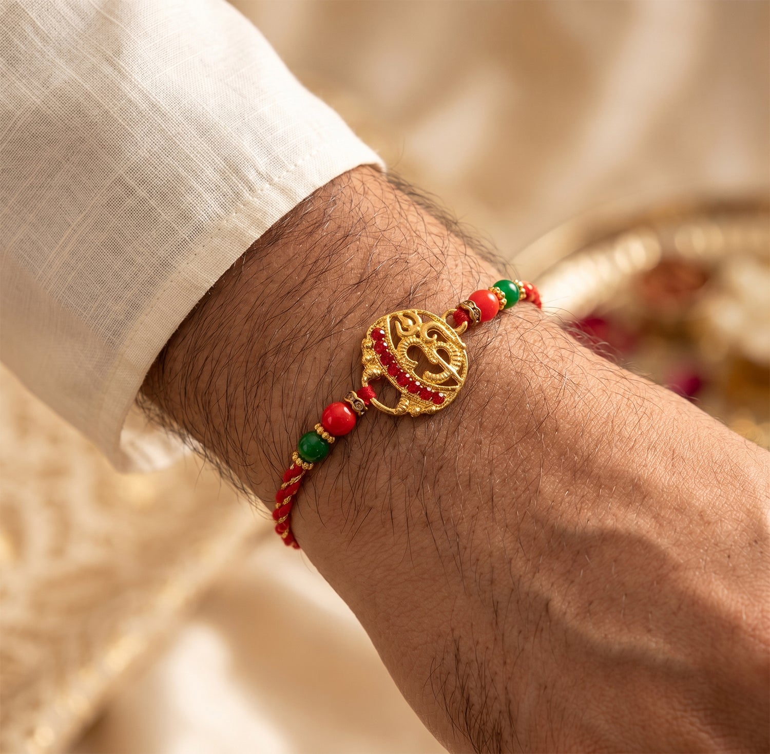Golden Red Diamond Om Trishul Rakhi with Green Beads and Twisted Thread