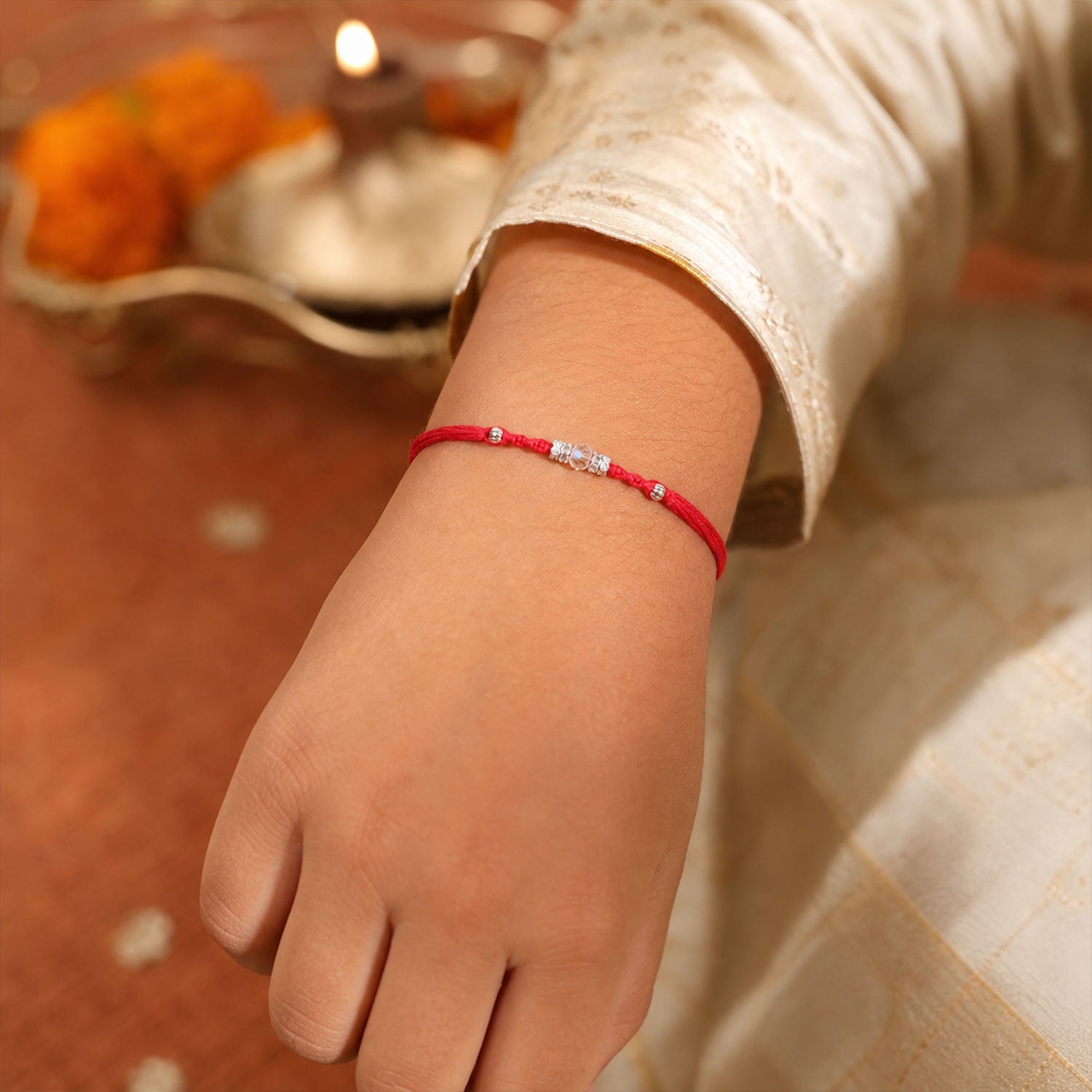 Red Braided Rakhi with a Row of Sparkling Crystal Bead Accents
