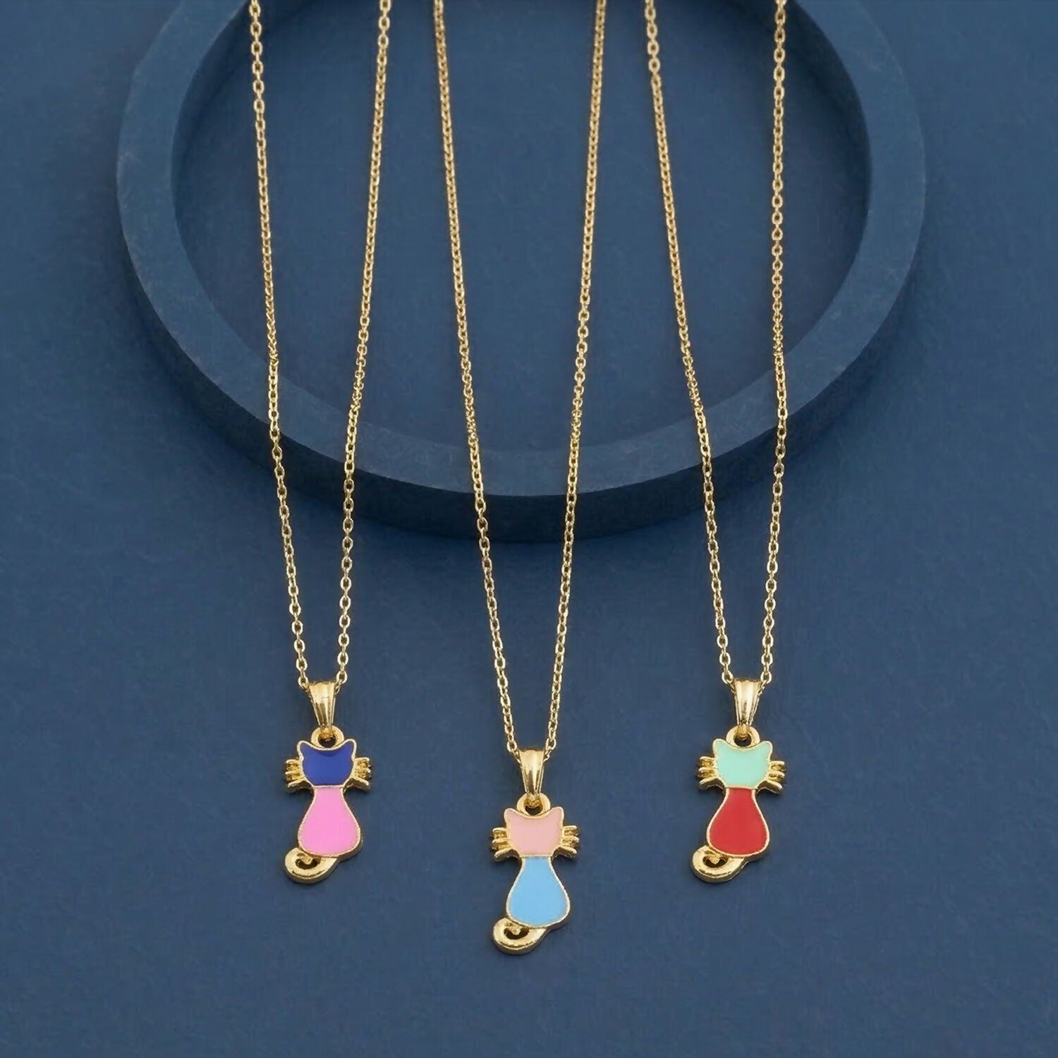 Gold cat pendant necklace with colorful enamel charm on white background