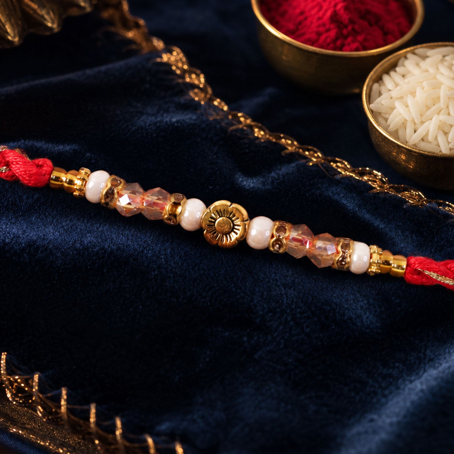 Red Thread Rakhi with Pearls, Crystal Beads and a Gold Flower Charm