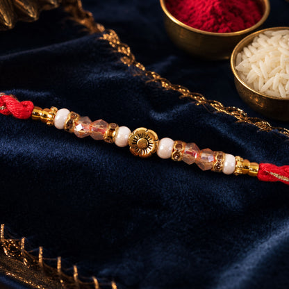 Red Thread Rakhi with Pearls, Crystal Beads and a Gold Flower Charm