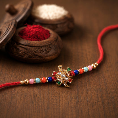 Cute Turtle Design Rakhi with colorful beads and stone-studded centerpiece