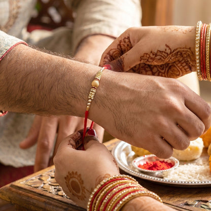 Golden bhabhi rakhi showing pearl drop latkan detail