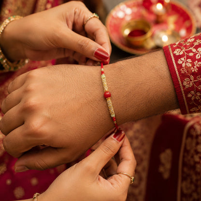 Red Pearl Bhabhi Rakhi with Golden Charm in hand