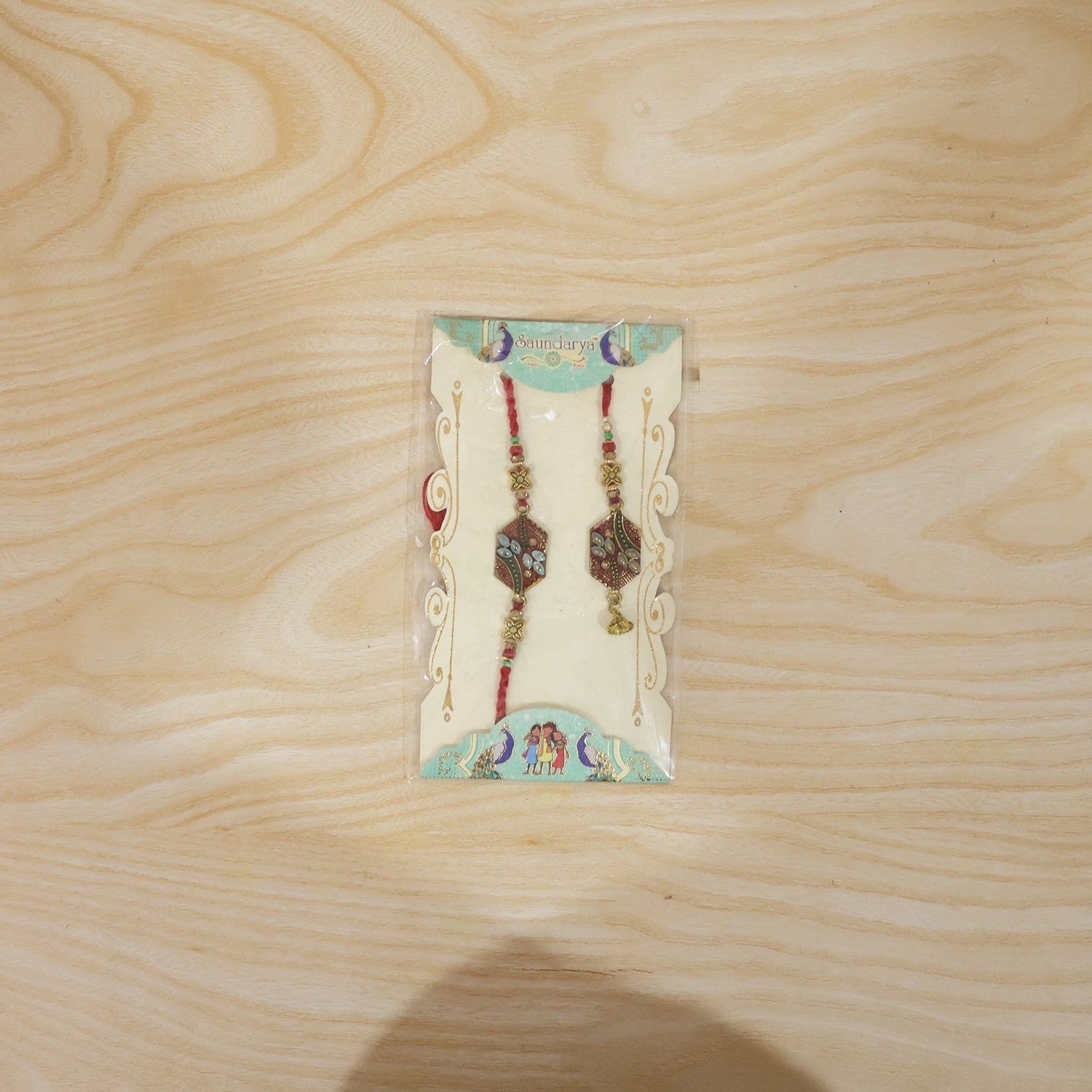 Meenakari Pot Bhabhi Rakhi with threads shown