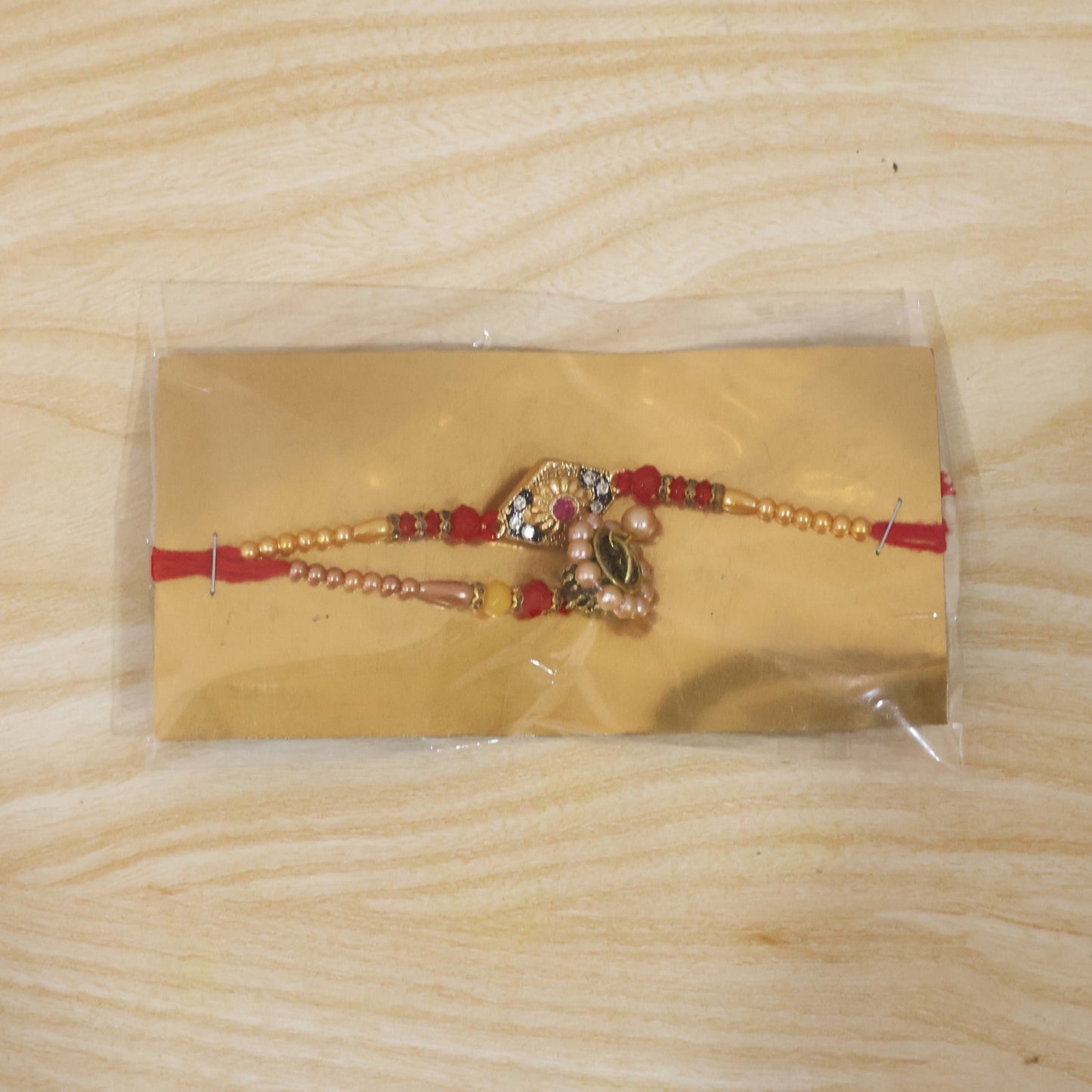 Pearl Jhumka hanging from Diamond Shape Stone Rakhi