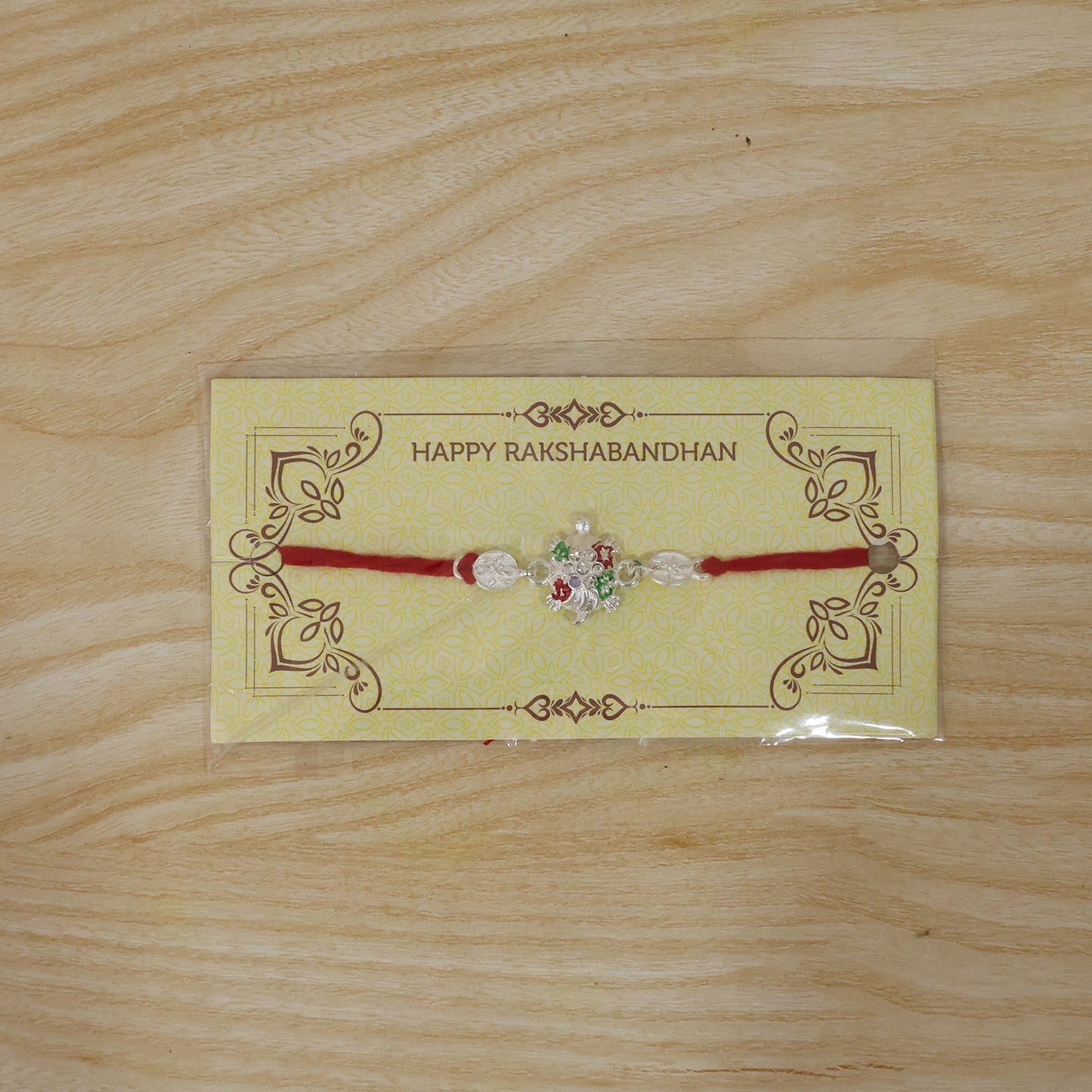 Silver rakhi with floral and bead design on comfortable thread