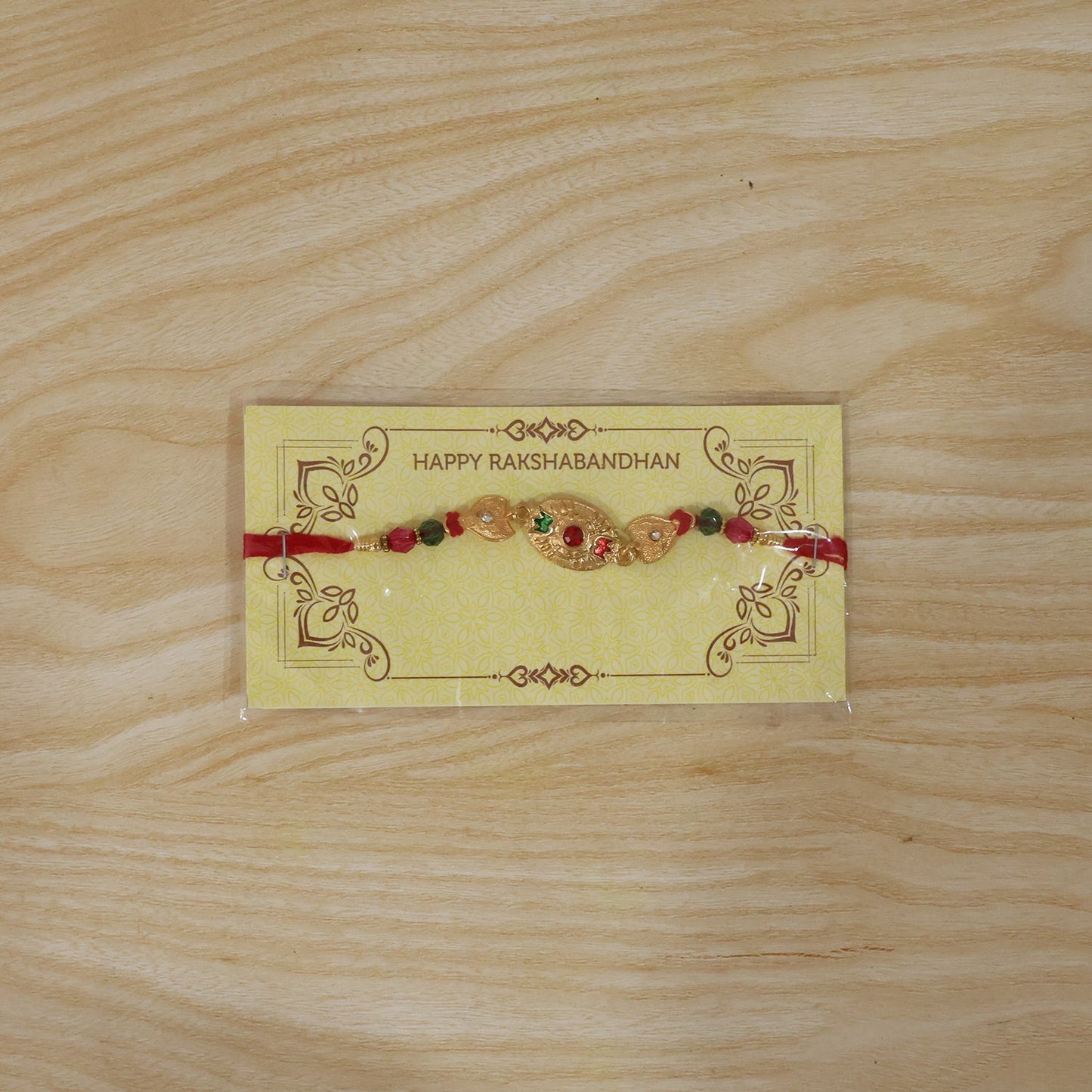Elegant golden Rakhi with vibrant bead accents