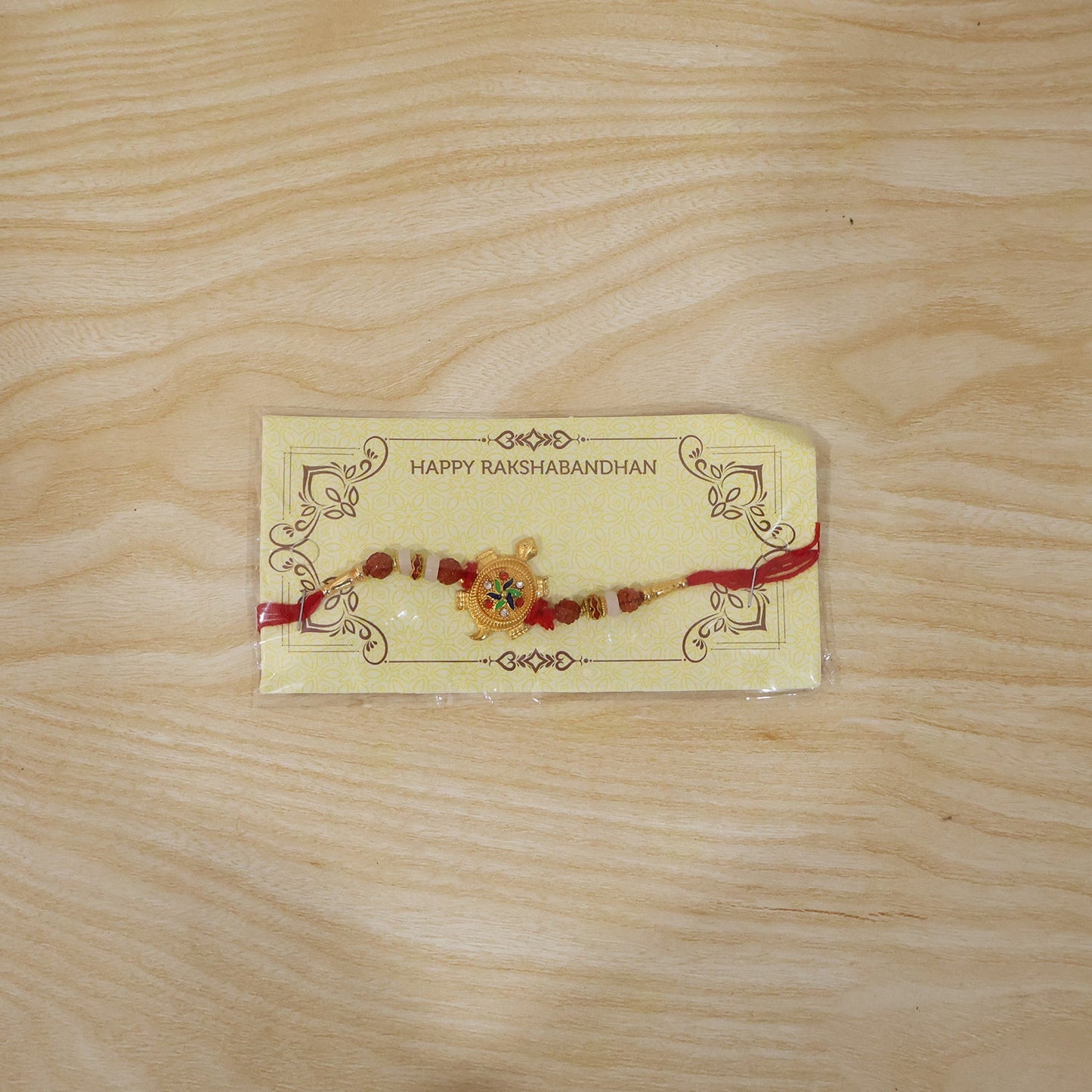 Traditional Rakhi with turtle centerpiece and Rudraksha beads close-up