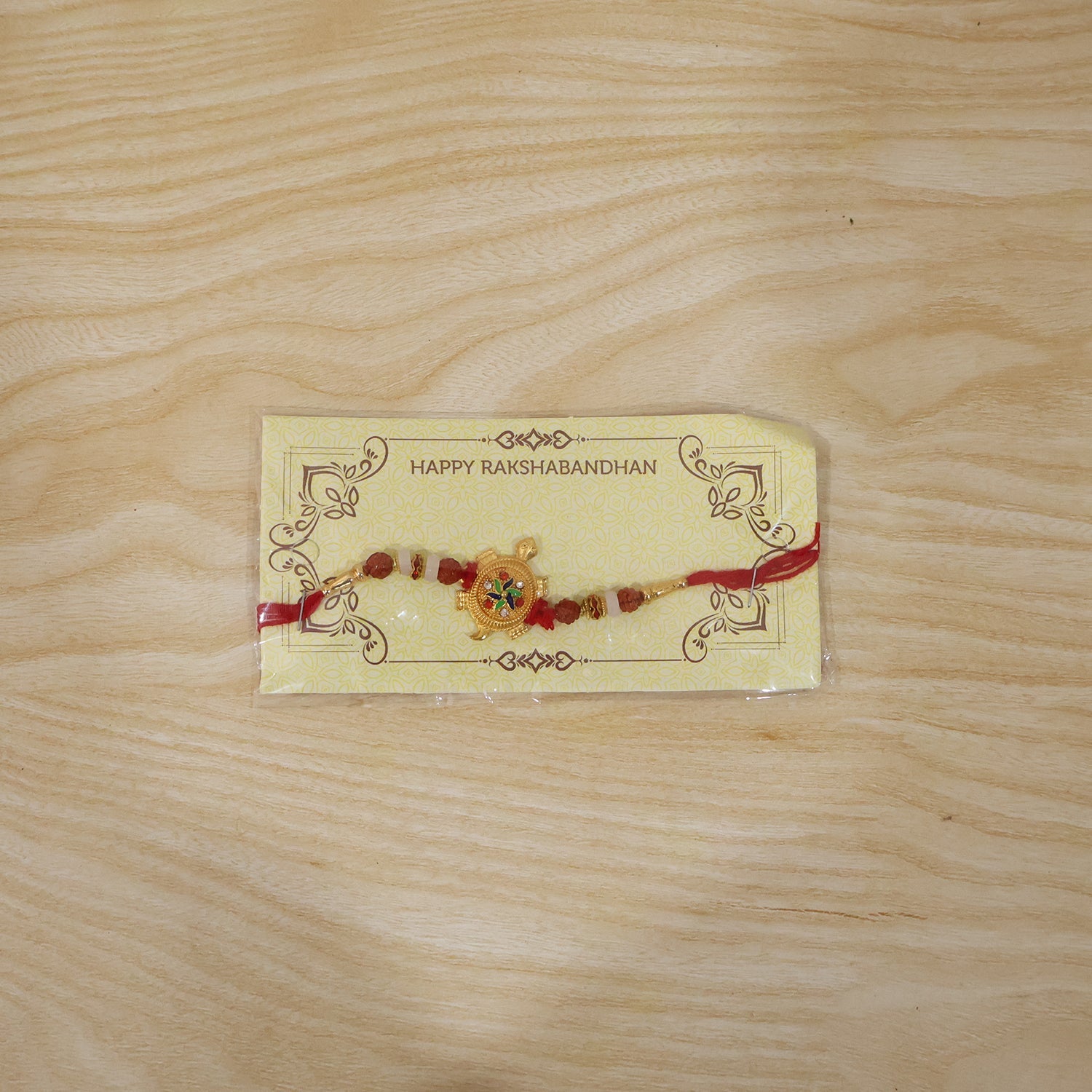 Traditional Rakhi with turtle centerpiece and Rudraksha beads close-up