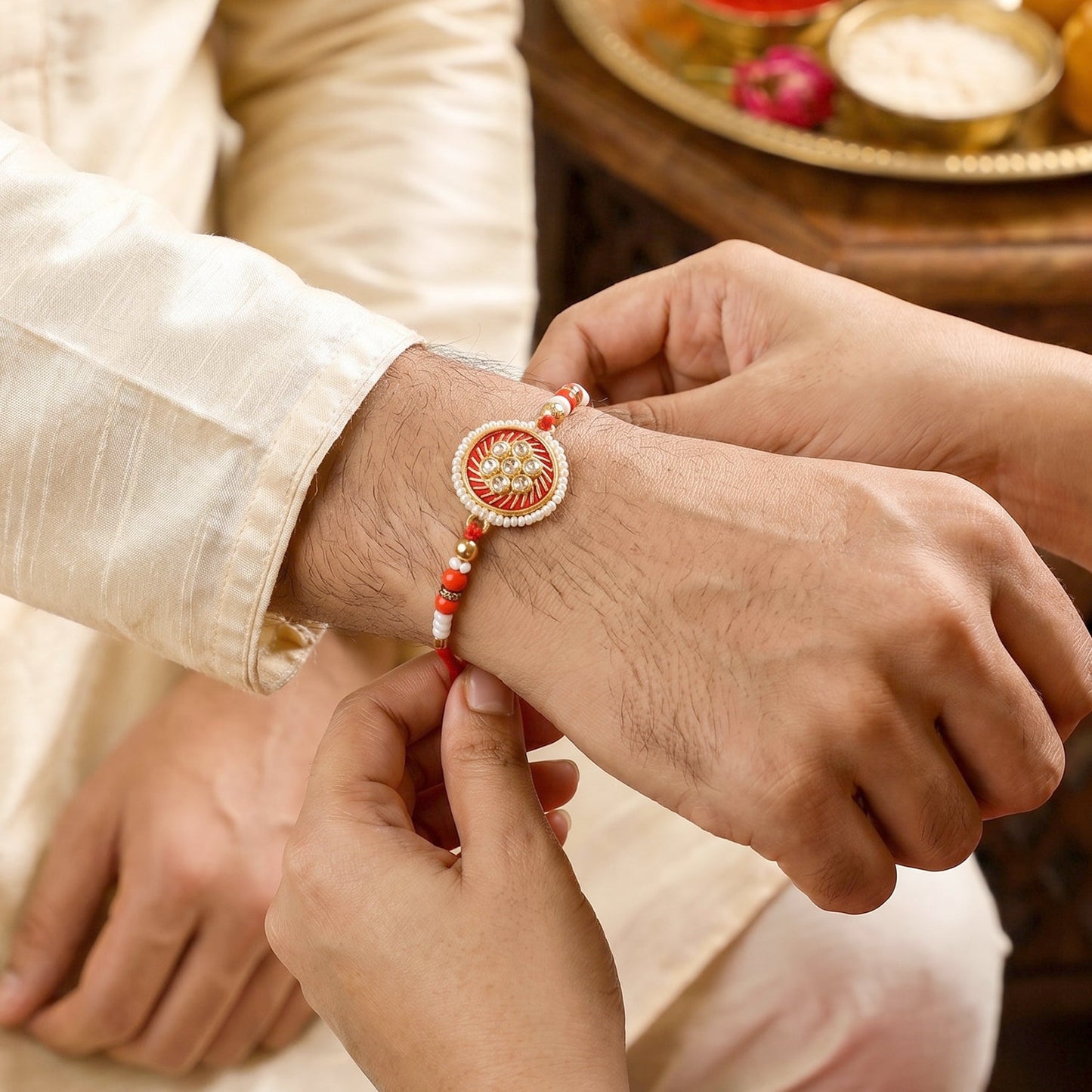 Golden floral rakhi tied on soft thread laid flat