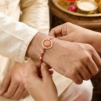 Golden floral rakhi tied on soft thread laid flat