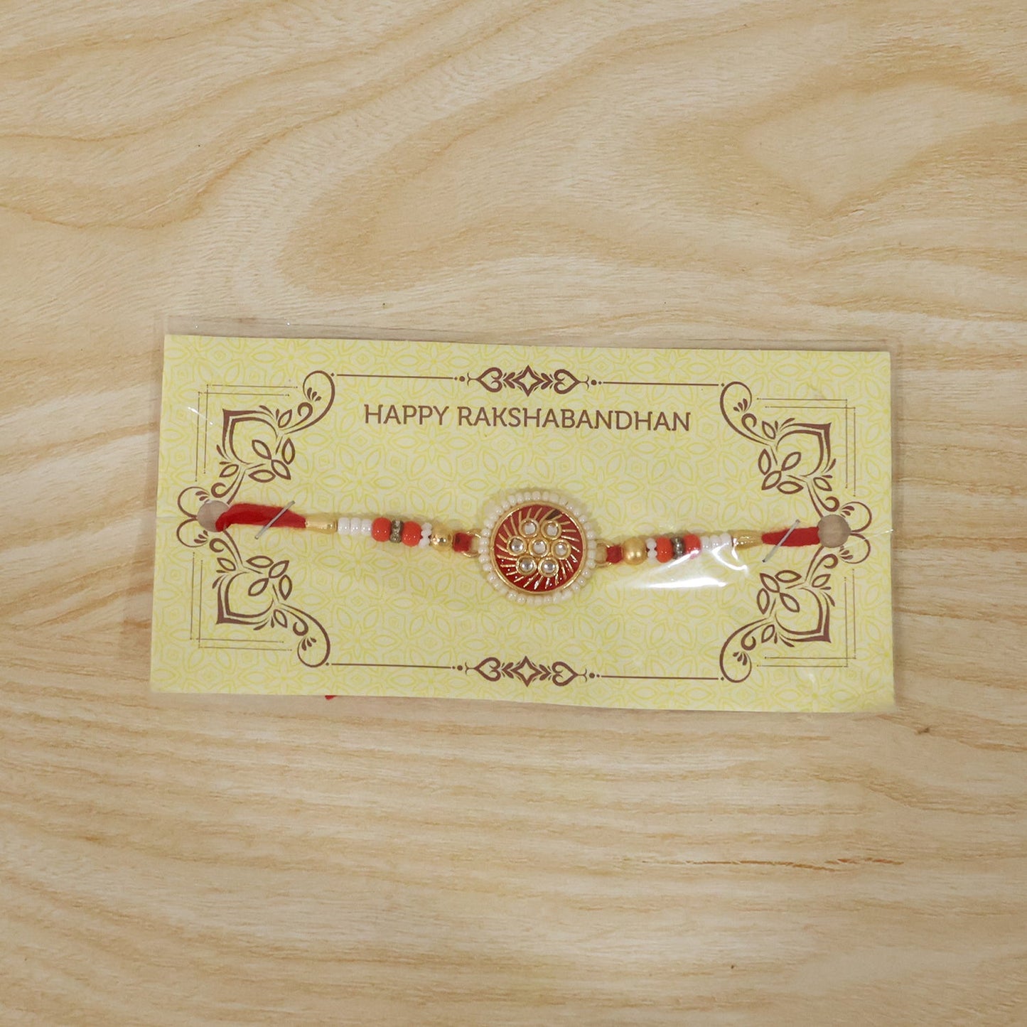 Festive rakhi with golden floral centerpiece and beads