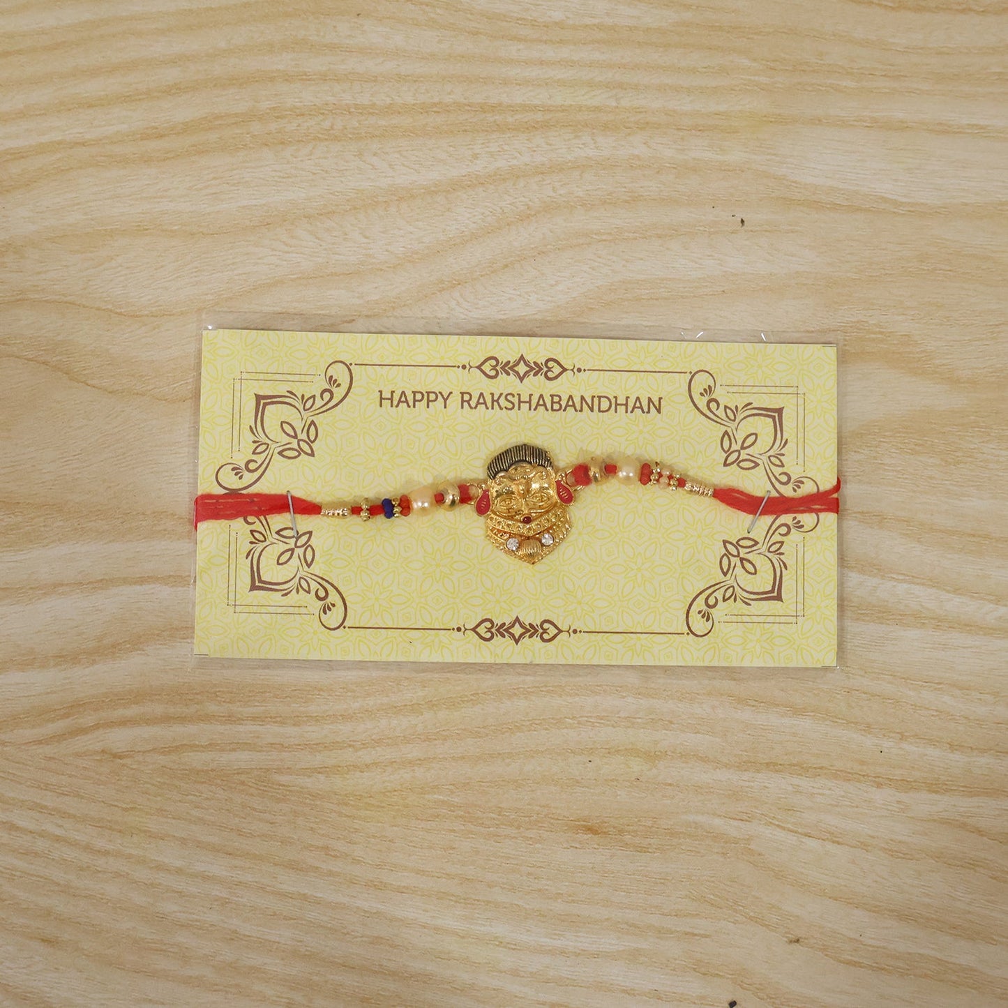 Fully spread traditional rakhi with decorative beads and red thread