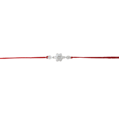 Silver Om rakhi showing intricate floral details and red thread