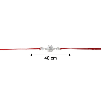 Red thread tied to silver floral Om rakhi close-up