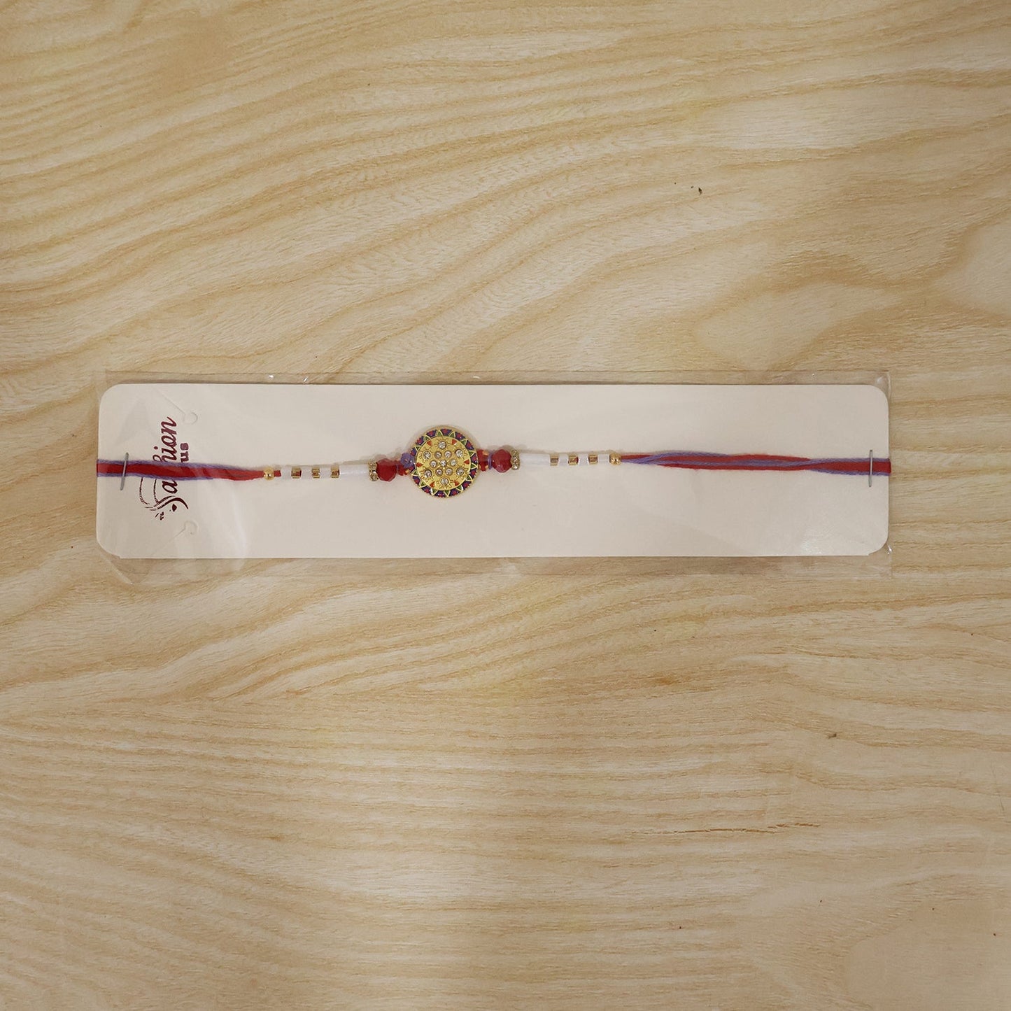 Designer Round Stone Rakhi with White Beads packaging