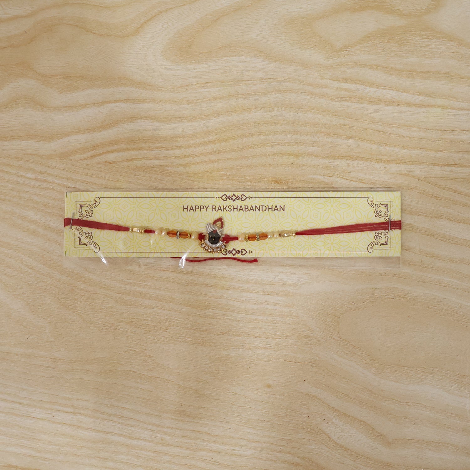 Traditional yet modern styled Shrinathji Designer Rakhi with red thread