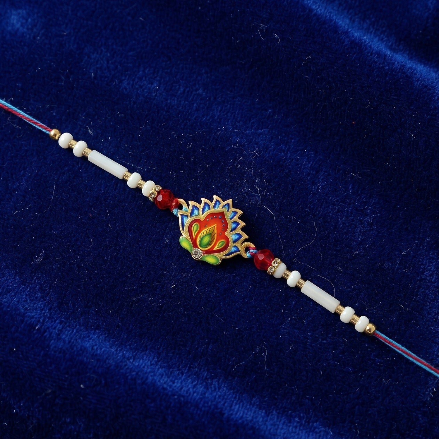 Hand holding colorful peacock feather rakhi with beads