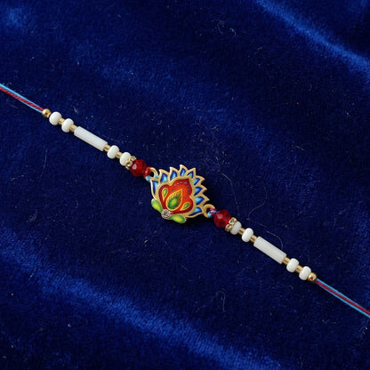 Hand holding colorful peacock feather rakhi with beads