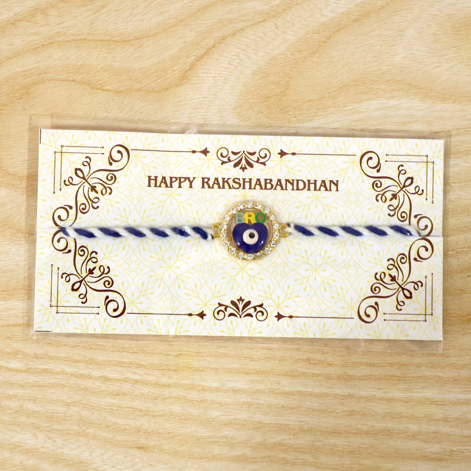 Blue evil eye fancy dori rakhi displayed flat on white surface