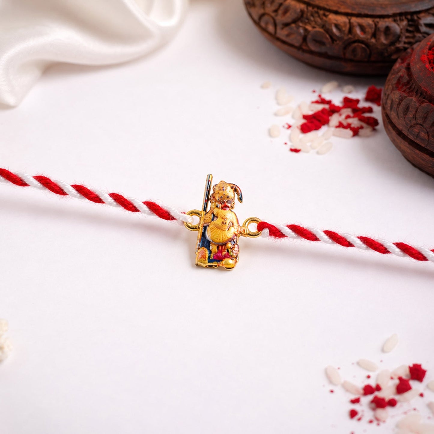 Side view of Hanuman Ji designer rakhi with orange and red thread