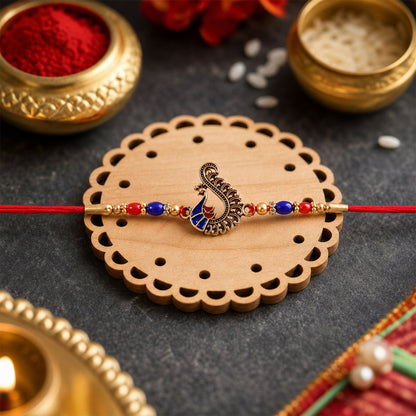 Close-up of peacock charm with colorful beads on rakhi
