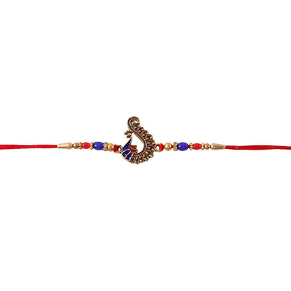 Hand holding antique peacock charm rakhi for brother