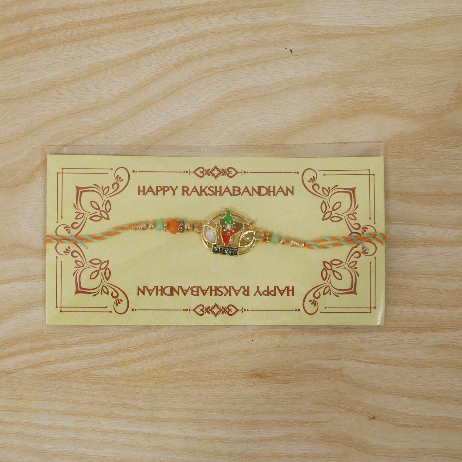 Close-up of India map charm on rakhi with beads