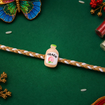 Close up of peach bottle charm on rakhi