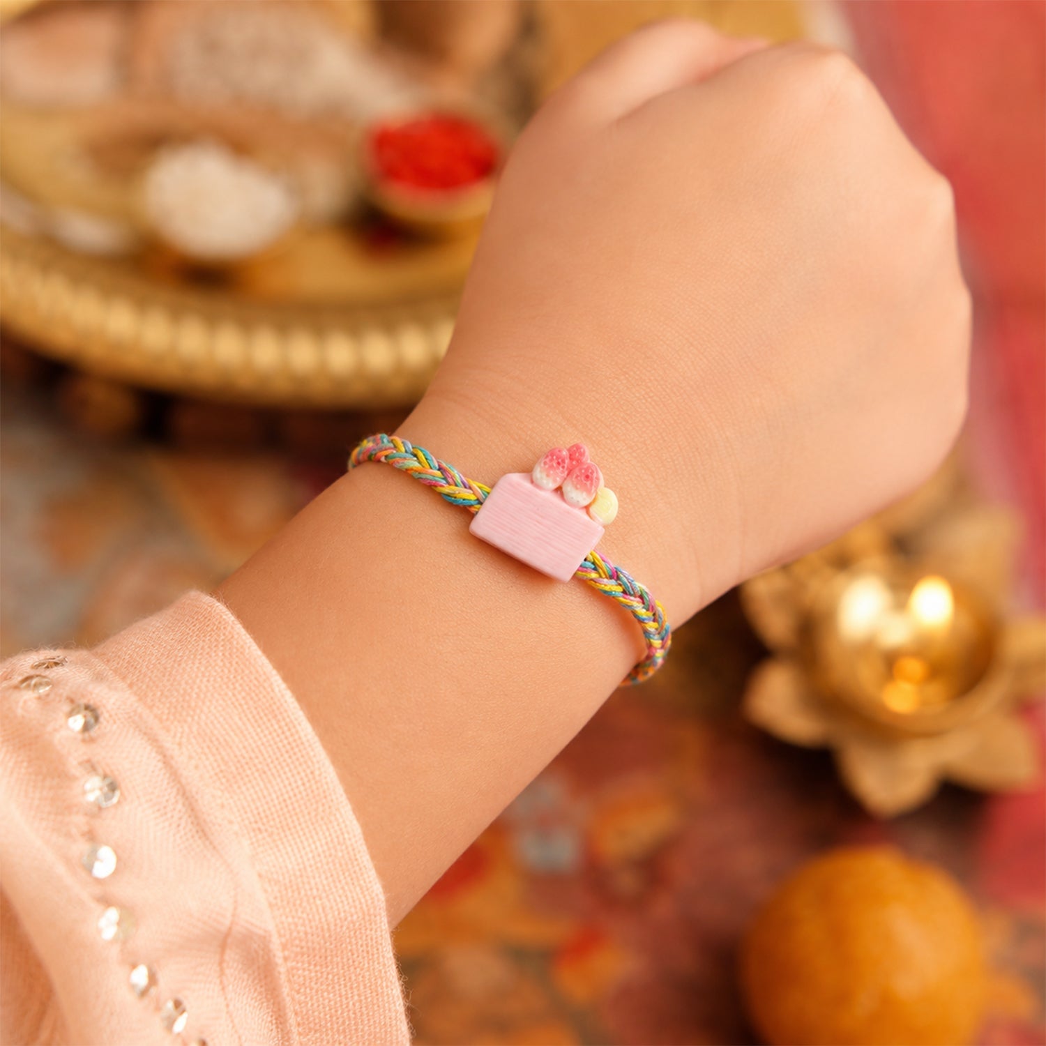 Rakhi tied with red thread and charm