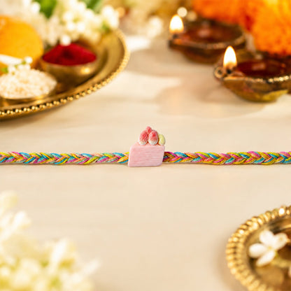 Close-up of Strawberry Cake Charm on rakhi