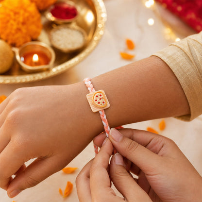 Close-up of heart pizza charm rakhi detail