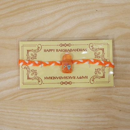 Fancy drink bottle charm rakhi tied neatly on white surface