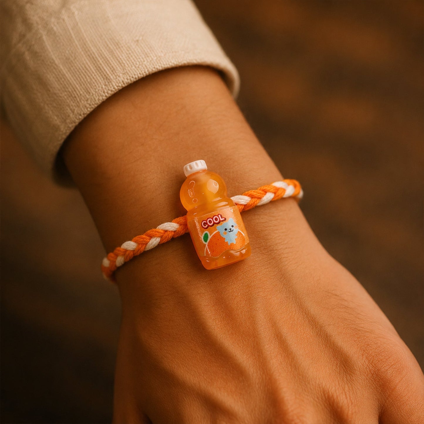 Top view of fancy drink bottle charm rakhi highlighting colorful threads