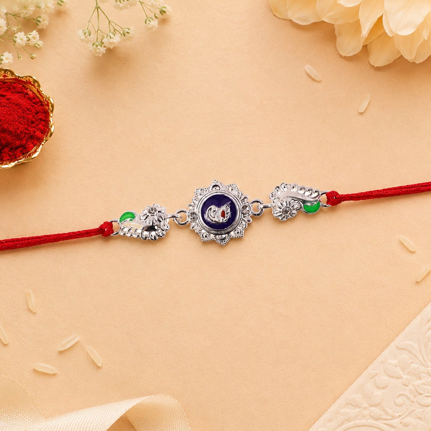 Silver round charm rakhi displayed on wooden surface