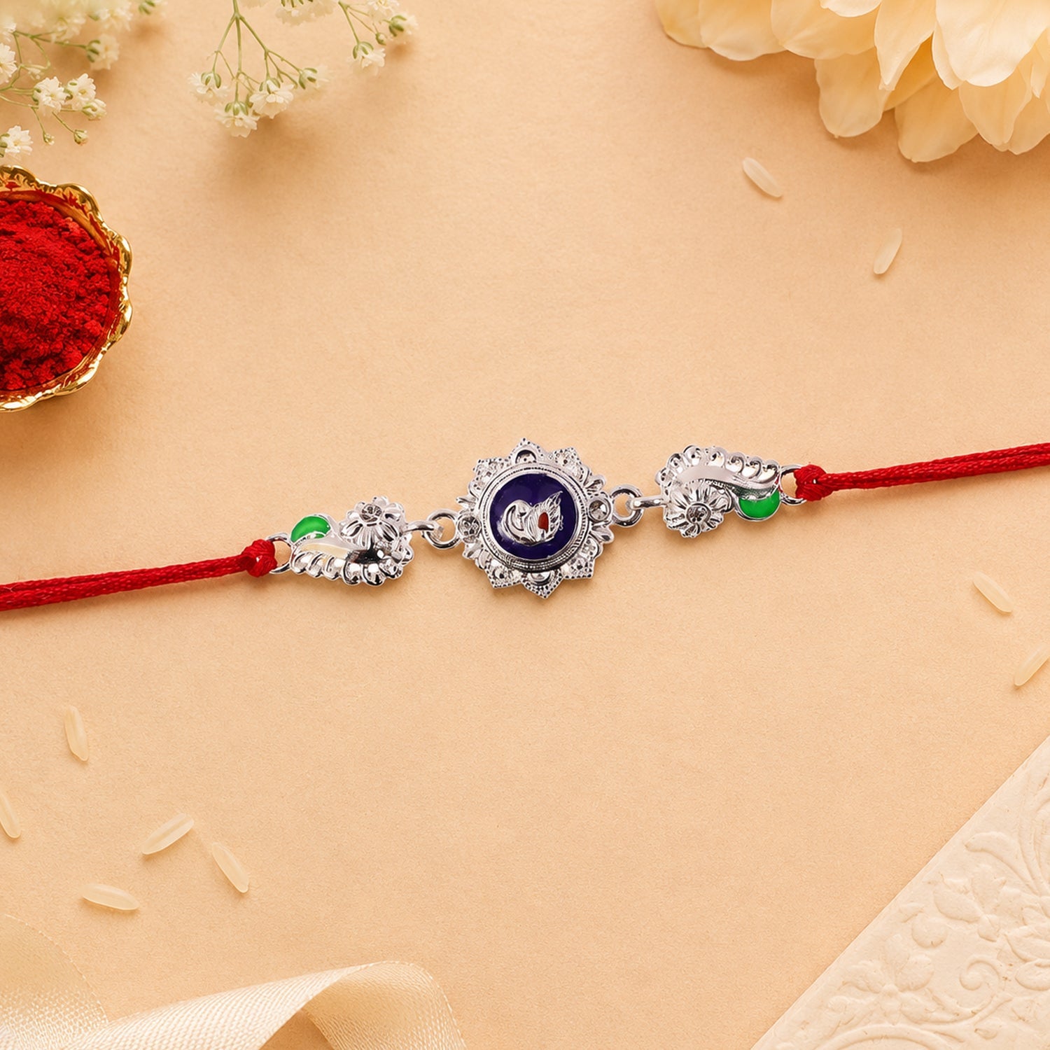 Silver round charm rakhi displayed on wooden surface