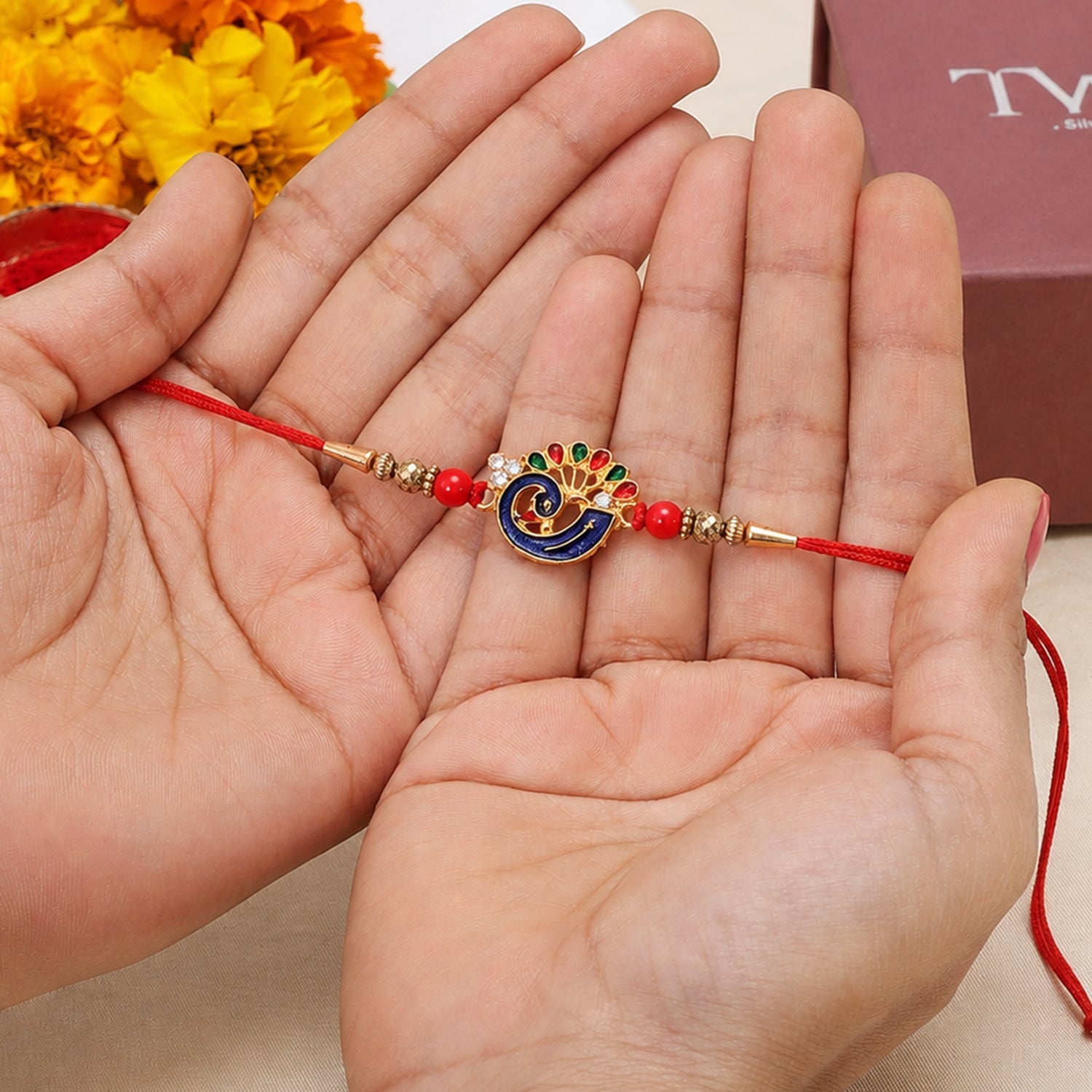 Side angle of Peacock Charm Rakhi with red beads