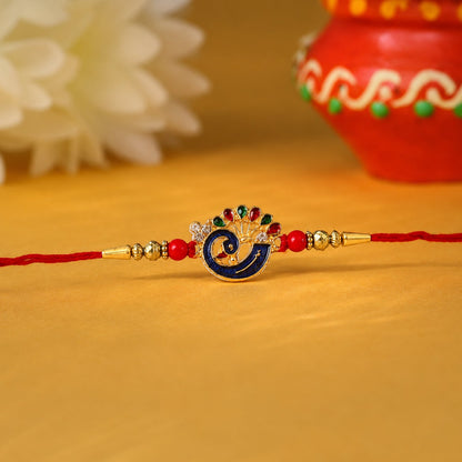Close-up of Peacock charm on red bead rakhi