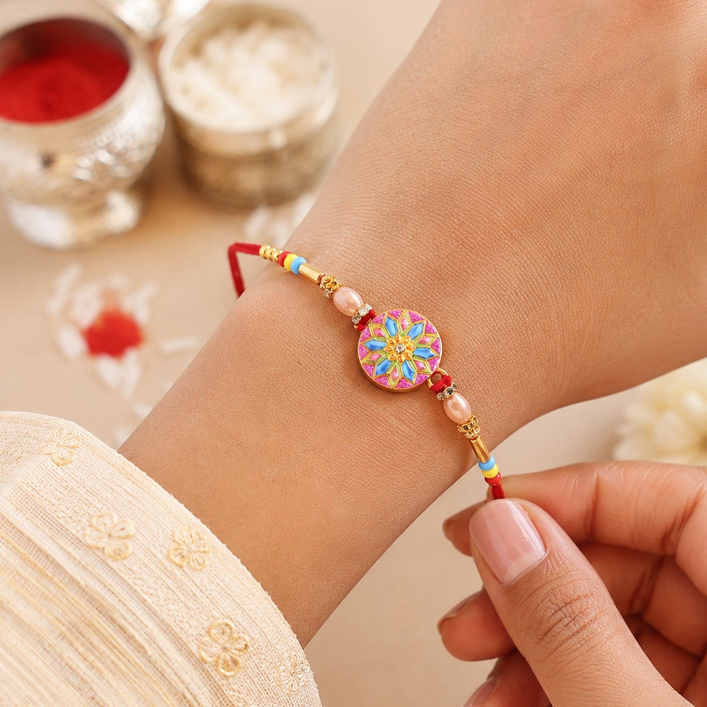 Designer rakhi showing detailed meenakari charm and beads