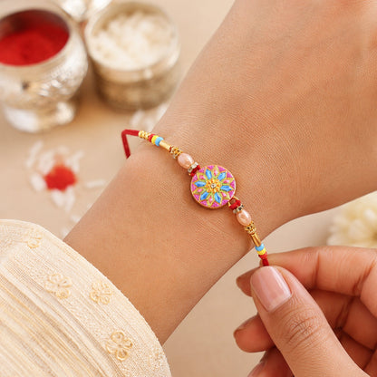Designer rakhi showing detailed meenakari charm and beads