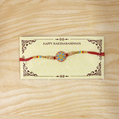 Elegant designer rakhi featuring meenakari charm and beads